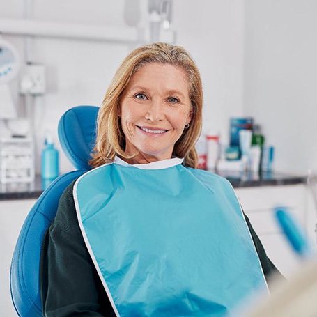 Senior woman sitting in dental chair and smiling