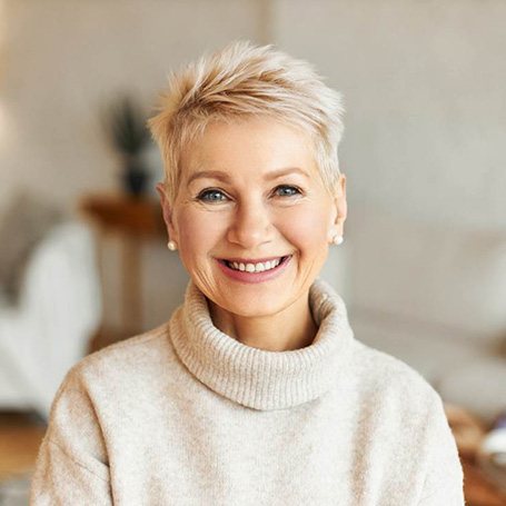 Smiling senior woman in white sweater